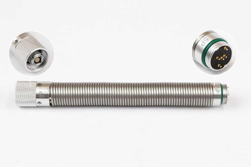 A stainless steel spring with 5 pin and 6 pin connectors on opposite ends.